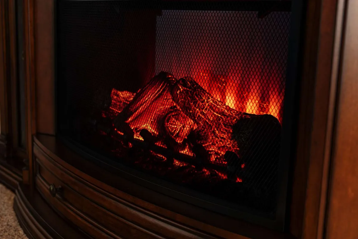 A warm, inviting fireplace glows with stacked logs, creating the perfect spot to relax and share stories. The setting is cozy and romantic, ideal for couples seeking a relaxing evening together.