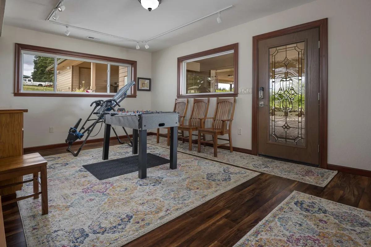 Inside, a foosball table stands ready for spirited matches, surrounded by wooden chairs and a cozy decorative rug. The arrangement suggests a fun, casual space for friendly competition and laughter among friends or family.