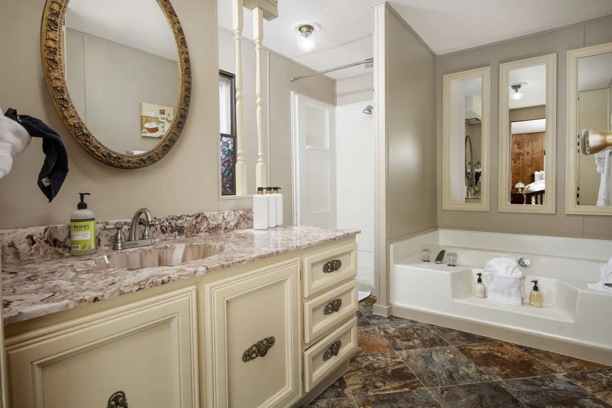 A spa-like bathroom with a sleek vanity, a large mirror, and an inviting bathtub. The overall mood is serene and luxurious, evoking a sense of relaxation and self-care rituals.